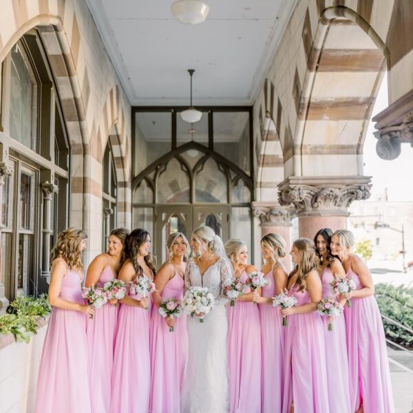 bride and bridesmaids in pink gowns on venue porch