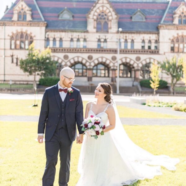 bride and groom walking through old post office lawn