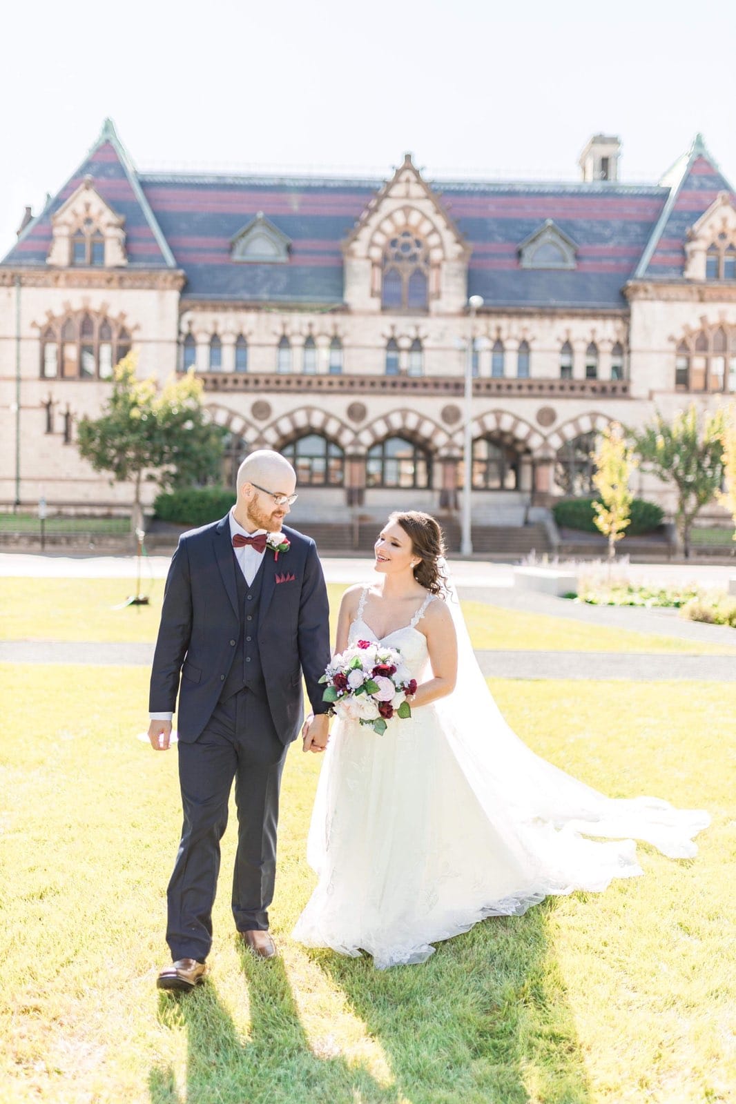 bride and groom walking through old post office lawn