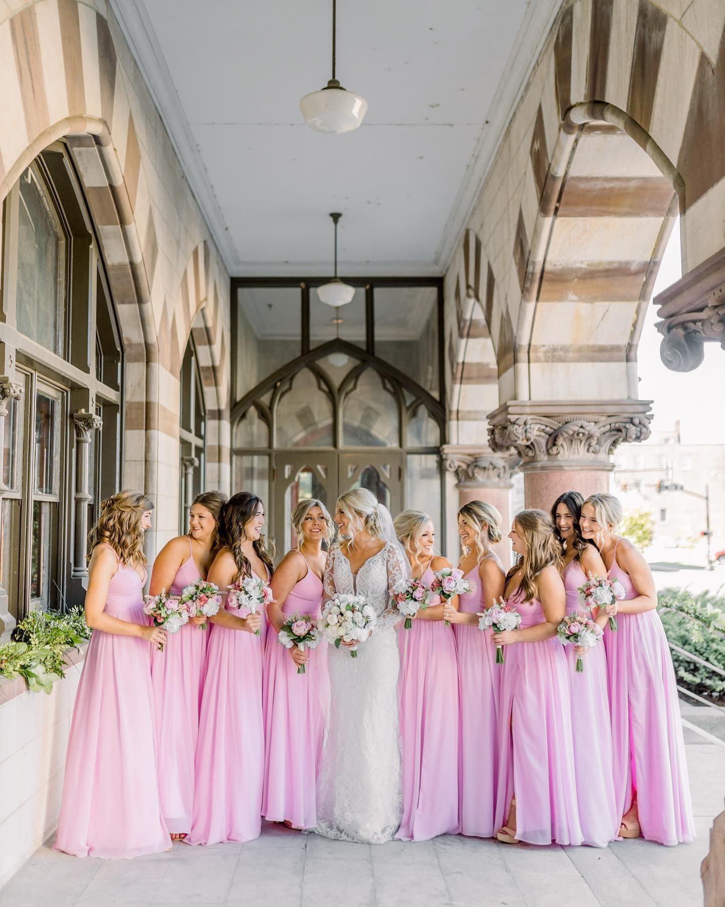 bride and bridesmaids in pink gowns on historic venue porch